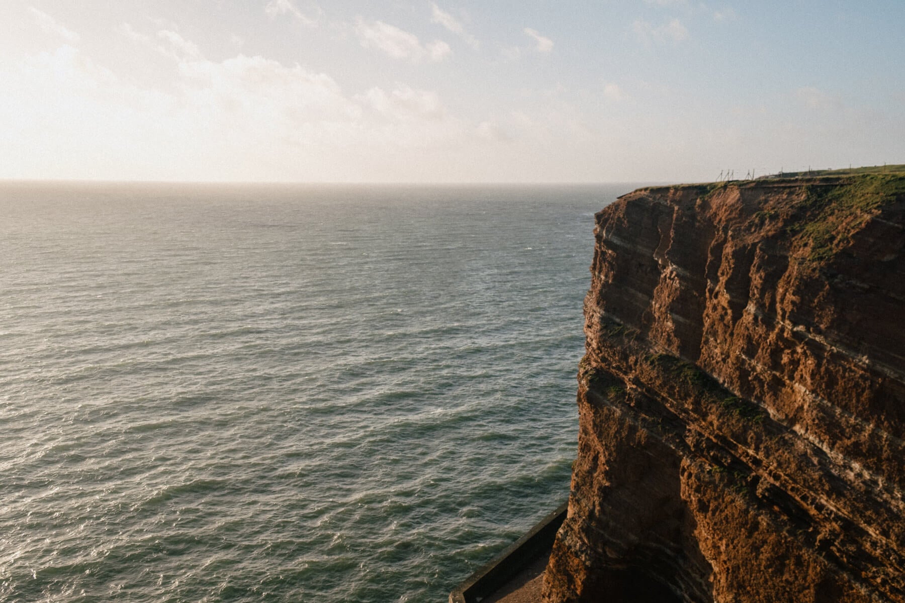 Cliff overlooking the ocean with a clear sky
