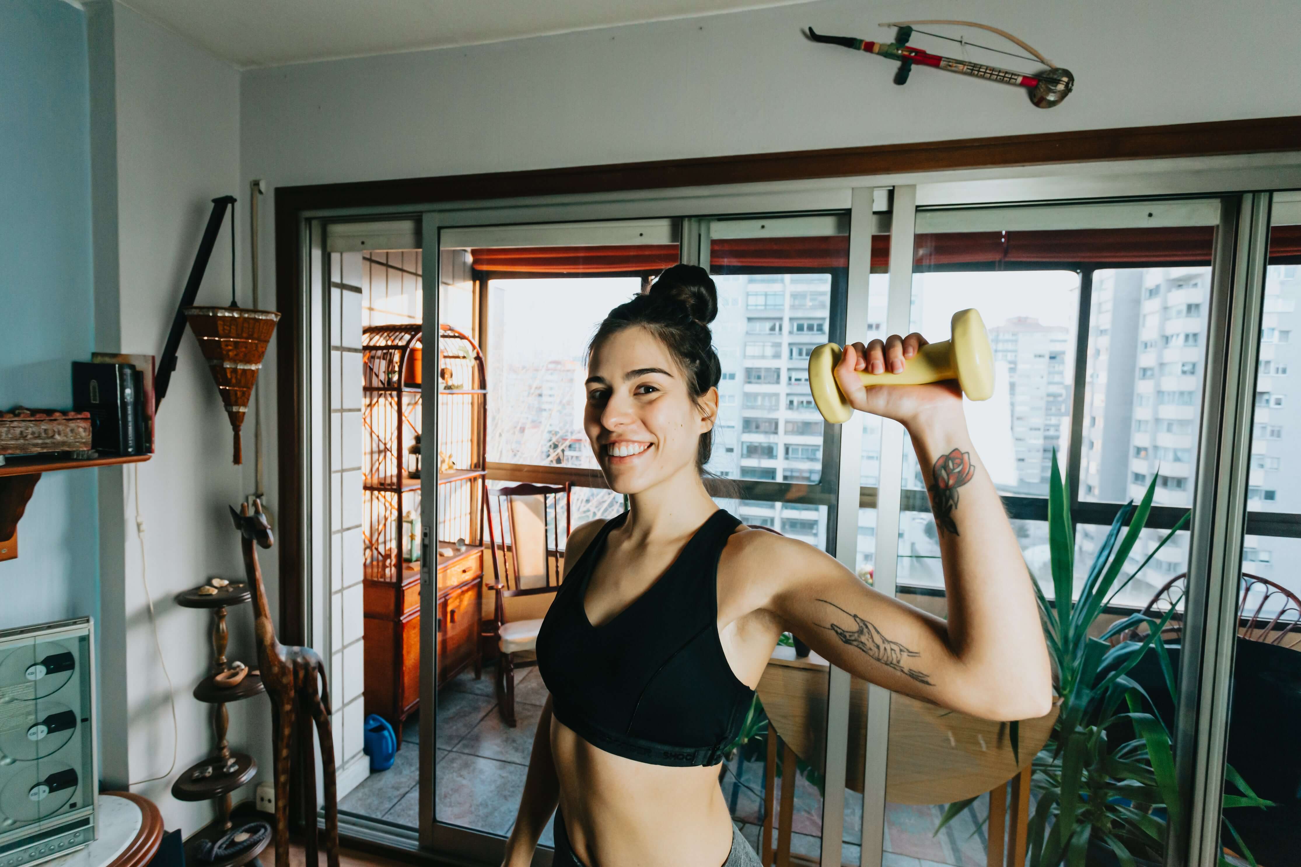 Woman exercising with a dumbbell in a home setting
